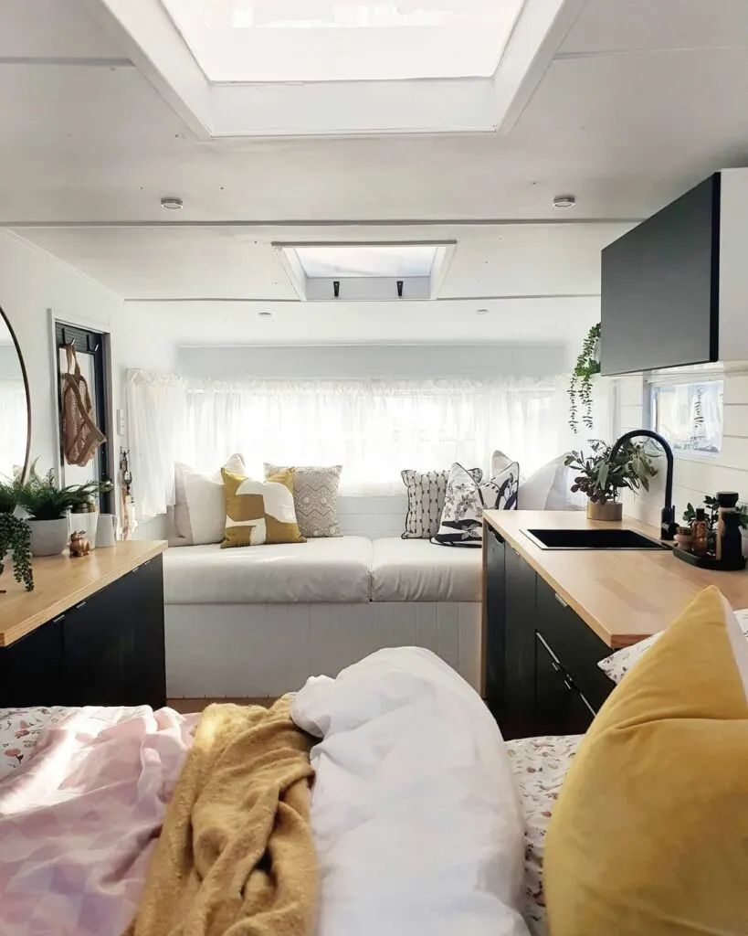 Interior of a restored vintage caravan looking at the sofa, from the bed end.