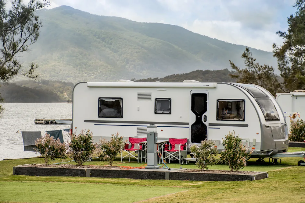 Caravan parked beside a lake.