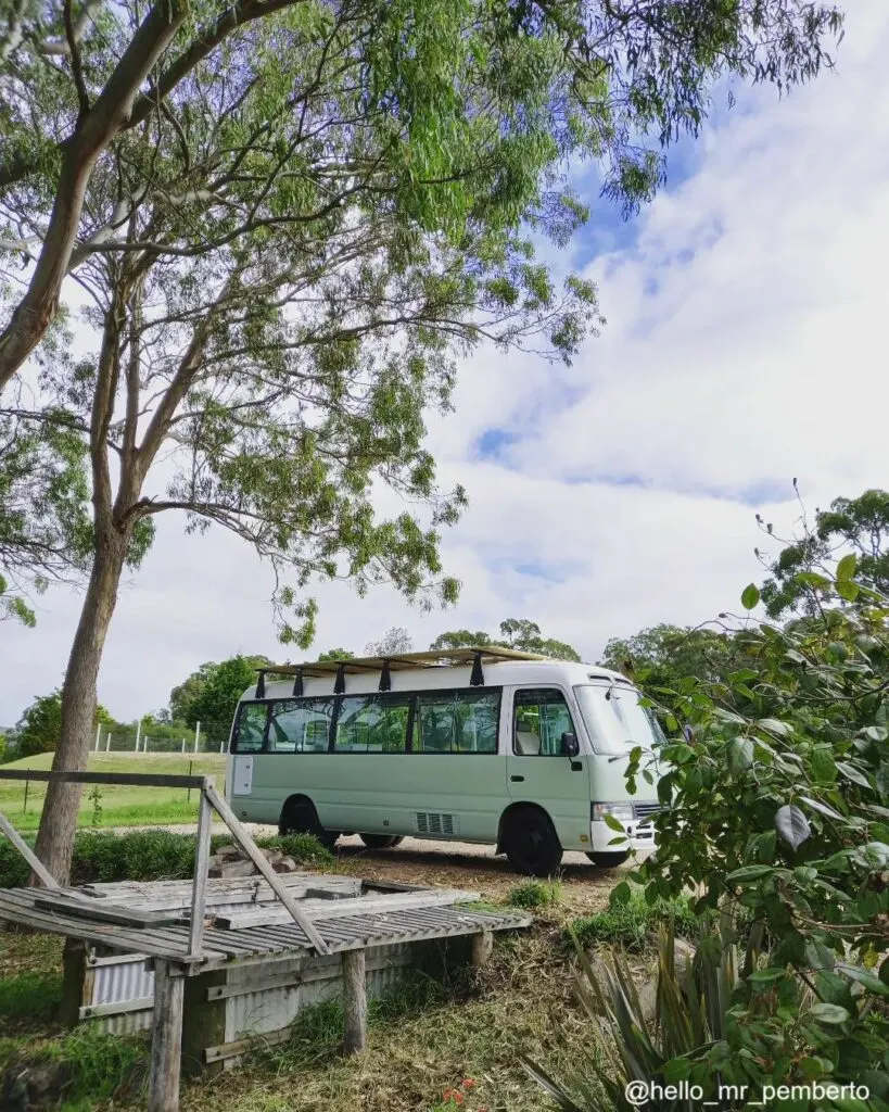 Side view before and after photos of a Toyota Coaster campervan with new exterior paint job.